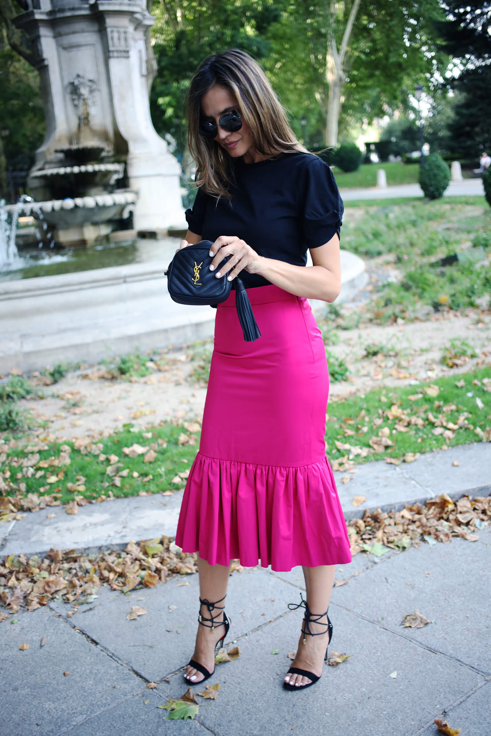 falda fucsia combinada con sandalias negras de tiras