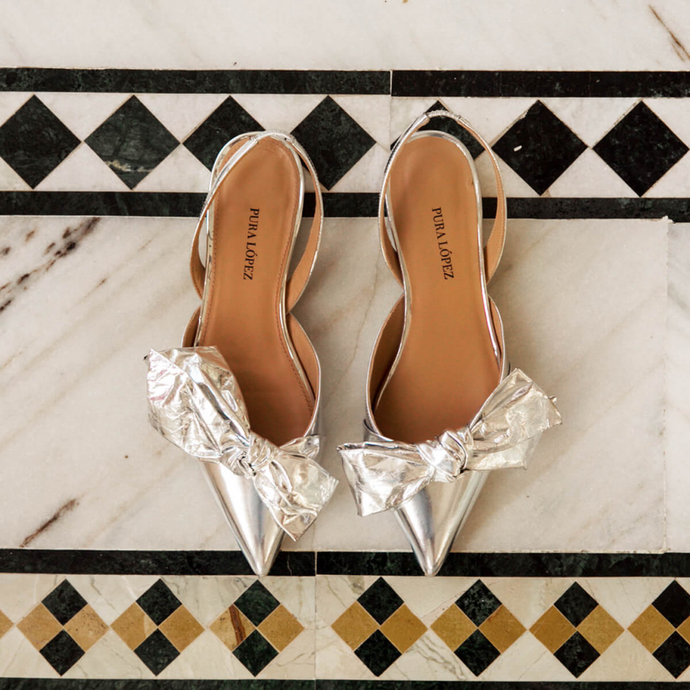 Bow detailed pointy toe flats in silver mirrored leather