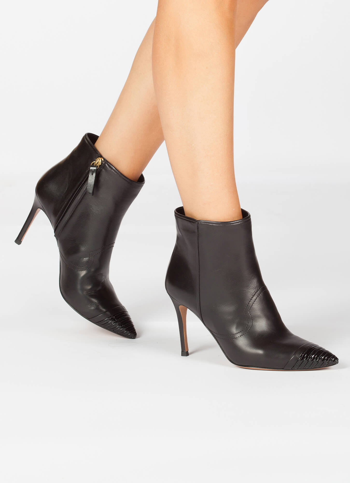 Black high heel ankle boots with a patent pointy toe . PURA LOPEZ