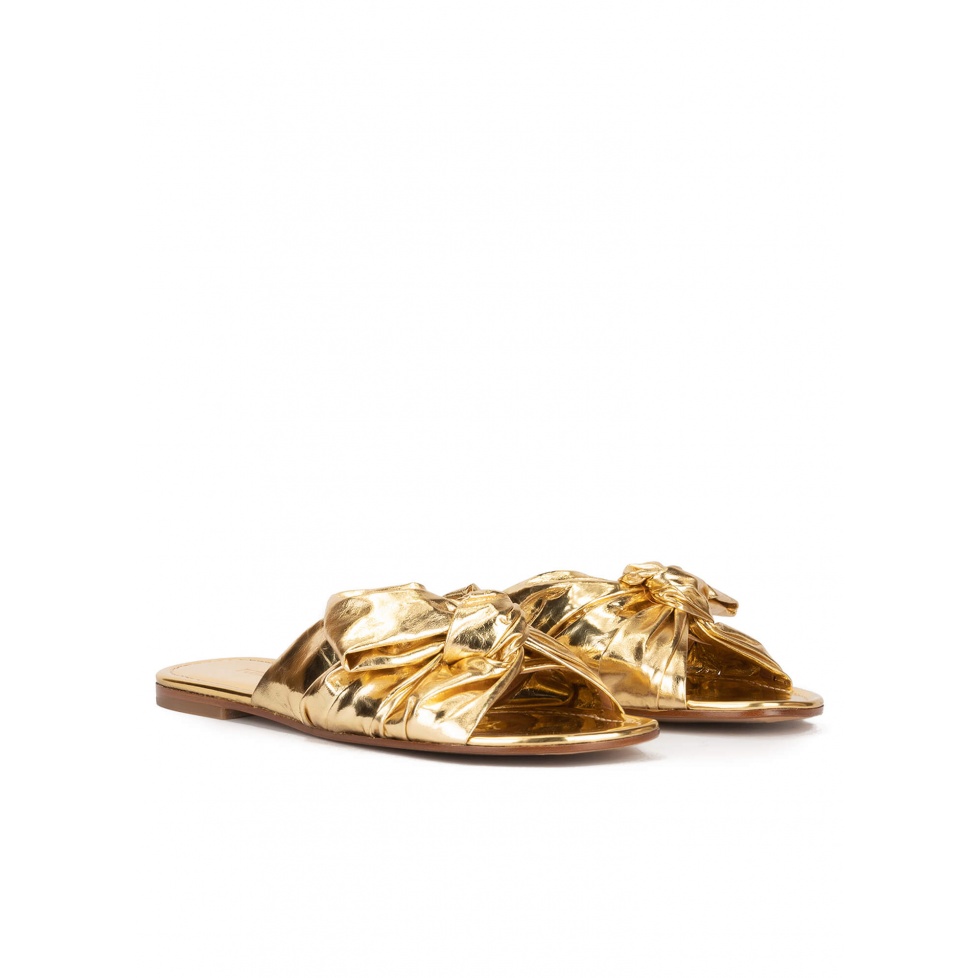 Gold flat sandals with bow detail