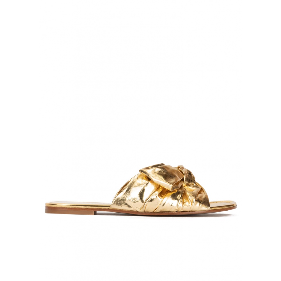 Gold flat sandals with bow detail