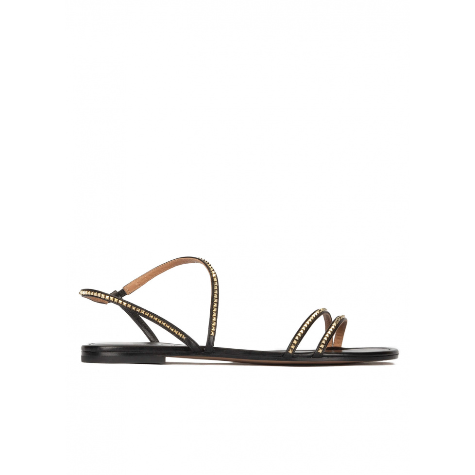 Strappy flat sandals in black leather with golden studs